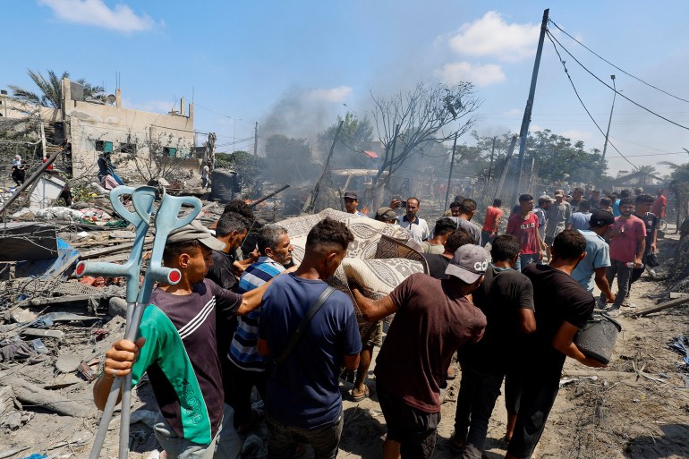 Palestinians carry a casualty at the site of what Palestinians say was an Israeli strike at a tent camp in Al-Mawasi area, amid Israel-Hamas conflict, in Khan Younis in the southern Gaza Strip July 13, 2024. REUTERS/Mohammed Salem