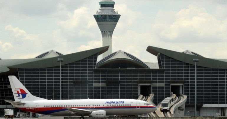 A Malaysian Airlines plane taxis for take-off as an Aero-Train (R) enters the international terminal at Kuala Lumpur International Airport (KLIA) in Sepang on August 19, 2010. Authorities are shutting down the KLIA Aero-Train Service till 27 September 2011 for modifications to the existing train and the addition of one three-car train to handle the current load of passengers. AFP PHOTO/ Saeed Khan (Photo by SAEED KHAN / AFP)