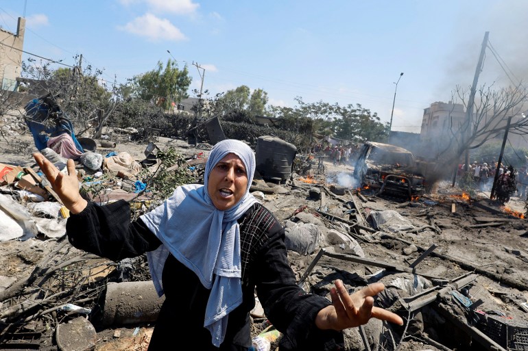 A Palestinian woman reacts near damages, following what Palestinians say was an Israeli strike at a tent camp in Al-Mawasi area, amid Israel-Hamas conflict, in Khan Younis in the southern Gaza Strip July 13, 2024. REUTERS/Mohammed Salem