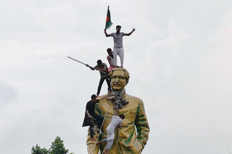 People climb the statue of Sheikh Mujibur Rahman, in DhakaPeople climb the statue of Sheikh Mujibur Rahman at the Bijoy Sarani area, as they celebrate the resignation of the Prime Minister Sheikh Hasina in Dhaka, Bangladesh, August 5, 2024. REUTERS/Mohammad Ponir Hossain TPX IMAGES OF THE DAY DATE 05/08/2024 SIZE 2293 x 1529 Country BANGLADESH SOURCE REUTERS/Mohammad Ponir Hossain