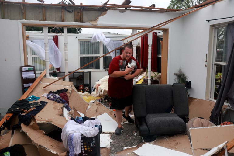 FORT MYERS, FLORIDA - OCTOBER 09: Robert Haight salvages what he can from his home after what appeared to be a tornado tore the roof off before Hurricane Milton's arrival on October 09, 2024, in Fort Myers, Florida. He said he had just had the roof replaced two years after Hurricane Ian had damaged it. People are preparing for the storm, which could be a Cat 3 when it makes landfall on Wednesday evening. Joe Raedle/Getty Images/AFP (Photo by JOE RAEDLE / GETTY IMAGES NORTH AMERICA / Getty Images via AFP)