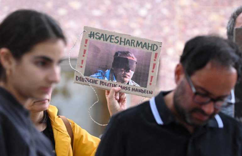 (FILES) A demonstrator holds a picture of Iranian-German Jamshid Sharmahd, who has been sentenced to death in Iran, with the lettering 'Save Sharmahd' and 'German politics has to act' during a demonstration for his release in front of the German Foreign Ministry in Berlin on July 31, 2023. Iran on October 28, 2024 executed 69-year-old German-Iranian Jamshid Sharmahd after years in captivity, media in the Islamic Republic said, sparking outrage in Germany and beyond. Berlin called the execution a "scandal" and warned of "serious consequences" for Iran's "inhumane regime", while a Norway-based human rights group labelled the execution the "extrajudicial killing of a hostage". Sharmahd, a German citizen of Iranian descent and a US resident, was seized by Iranian authorities in 2020 while travelling through the United Arab Emirates, according to his family. (Photo by INA FASSBENDER / AFP)