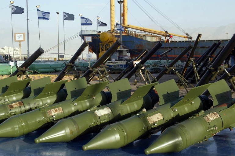 Anti-tank Russian made Sagger missiles (foreground) and mortars seized on the cargo ship Karine-A (Background) are displayed in the Israeli Red Sea port of Eilat 06 January 2002. Israel said its navy, operating 03 January 2002 around 500 kilometres (310 miles) south of the Israeli port of Eilat, between Saudi Arabia and Sudan, seized the the ship carrying 50 tons of weapons and explosives. An Israeli official said the weapons were supplied by Iran to the Palestinian Authority. AFP PHOTO / Sven NACKSTRAND (Photo by SVEN NACKSTRAND / AFP POOL / AFP)