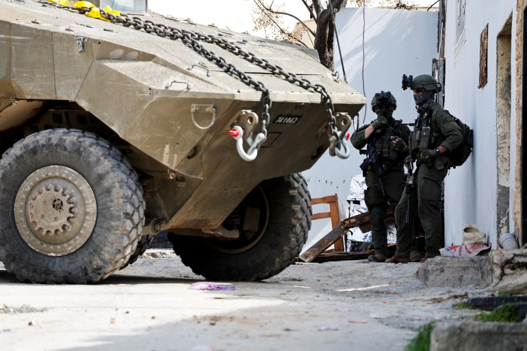 جنين - الضفة الغربية Israeli soldiers stand next to a military vehicle during an Israeli raid in Jenin, in the Israeli-occupied West Bank, March 4, 2025. REUTERS/Raneen Sawafta