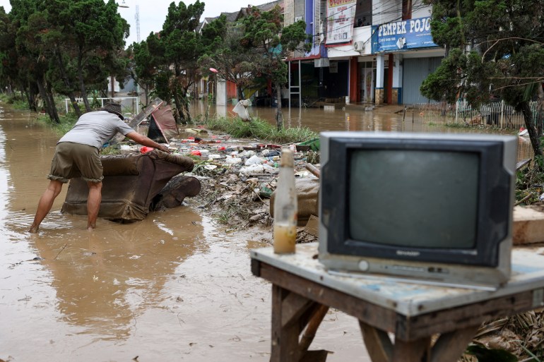 A man saves his goods as floods hit the residential area following heavy rains in Bekasi, on the outskirts of Jakarta, Indonesia, March 4, 2025. REUTERS/Ajeng Dinar Ulfiana