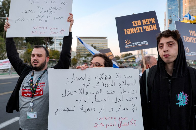 Demonstrators raise placards as they gather during an anti-government protest against the death of Gaza aid workers outside the Israeli Defence Ministry headquarters in central Tel Aviv on April 5, 2025. Israeli forces launched a ground offensive in Gaza City, the military said on April 4, after renewed military operations in March ended a short-lived truce in its war with Hamas. Israel has since expanding its operations pushed to seize territory in the Gaza Strip in what it said was a strategy to force militants to free hostages still in captivity. (Photo by Jack GUEZ / AFP)