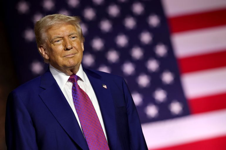 DOHA, QATAR - MAY 15: U.S. President Donald J. Trump stands on stage as he tours the Al Udeid Air Base on May 15, 2025, in Doha, Qatar. Trump is on the third day of his visit to the Gulf to underscore the strategic partnership between the United States and Qatar, focusing on regional security and economic collaboration. (Photo by Win McNamee/Getty Images)