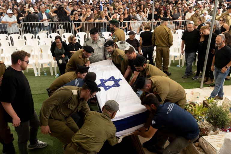 BEIT HASHMONAI, ISRAEL - APRIL 27: Israeli soldiers place a coffin covered with Israeli flag inside the grave during a funeral for Master Sergeant (res) Asaf Cafri killed in a battle in the northern Gaza Strip on April 27, 2025 in Best Hashmonai, Israel. According to the IDF, Cafri, a tank driver was hit and three other soldiers were wounded by sniper fire in the Beit Hanoun area, close to military post in the buffer zone. Beside Cafri, Police officer Sgt.Neta Yitzhak Kahane and commander Cpt. Ido Voloch were killed during fighting in Gaza City's Shejaiya neighbourhood, as IDF prepares for more offensive operation. (Photo by Amir Levy/Getty Images)