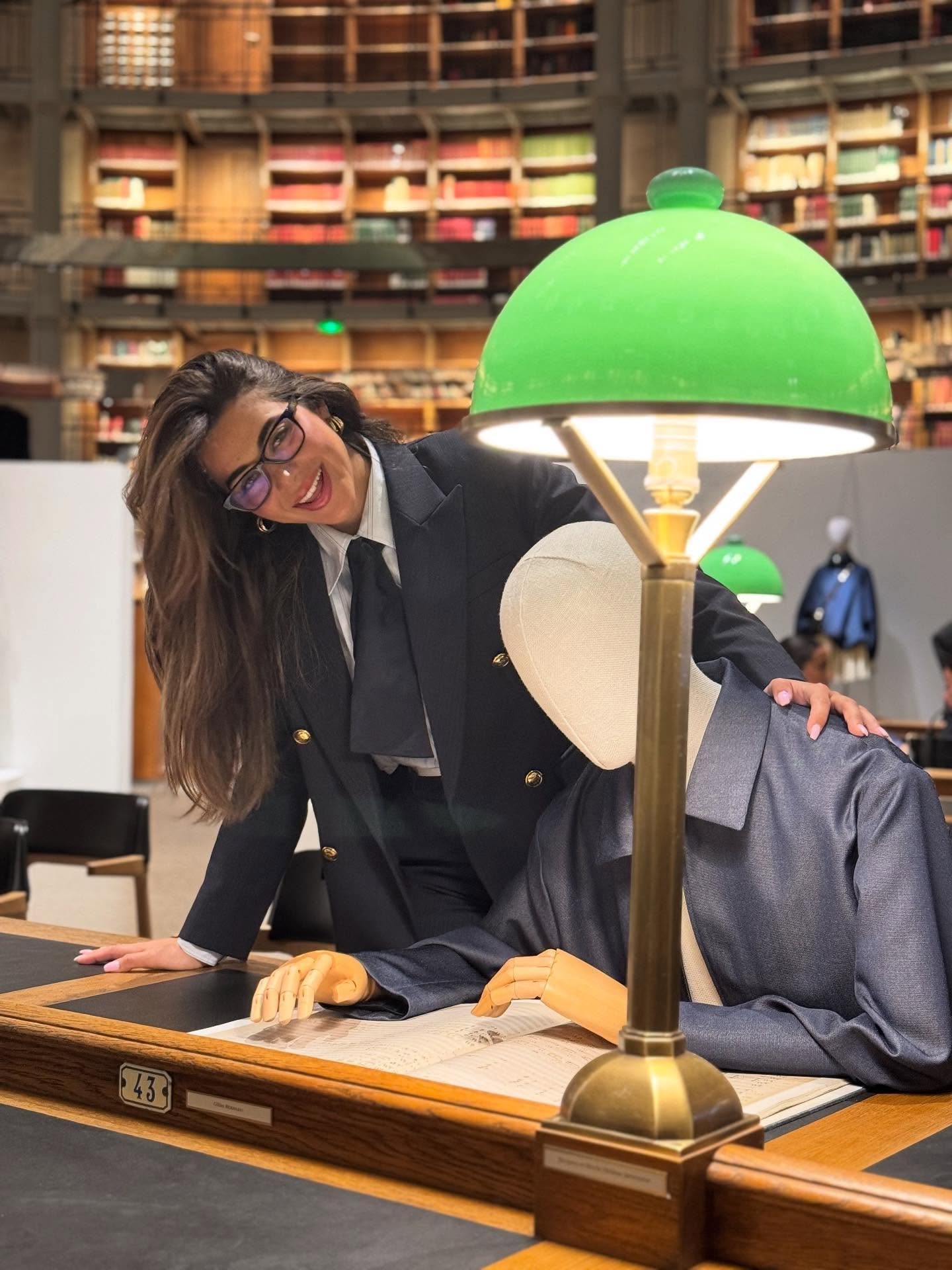 May be an image of 1 person, studying, glasses, overcoat, suit and text