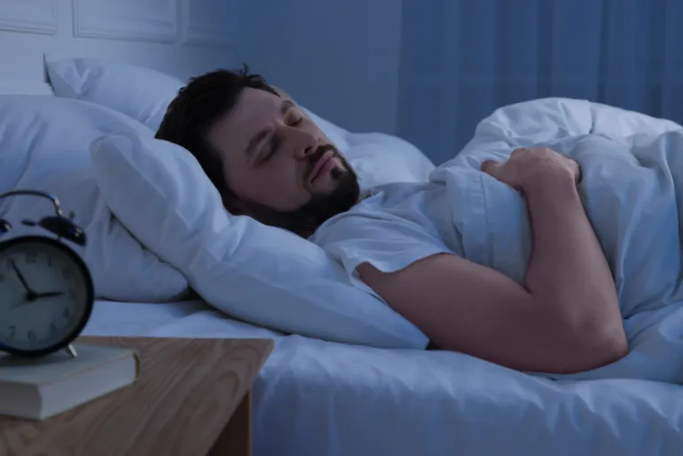 رجل وسيم نائم في سريره ليلاً